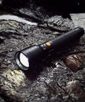 Ultra Bright Tactical Flashlight With 900 Lumen Zoomable Beam And Adjustable Focus, 3 Light Modes High Low Strobe, on wet rocks
