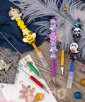 Colorful 12 Pack Beadable Letter Openers Set, Metal Beaded Envelope Openers With Plastic Protective Covers, shown on fabric