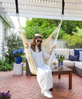 Woman relaxing in XL Hammock Chair With Hanging Hardware No Spreader Bar For Indoor Outdoor Lounging Beige 330 Lbs Weight Capacity.