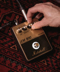 Hand adjusting controls on JCM800 Inspired Overdrive Distortion Guitar Pedal With Gain Sensitivity And Tone Controls Black And Gold Finish