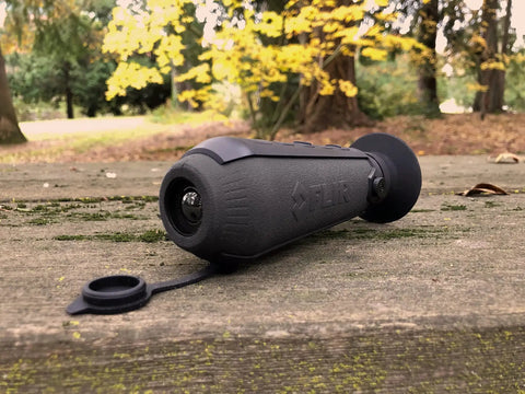 Compact Infrared Thermal Monocular for Night Wildlife on a wooden surface outdoors