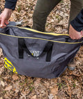 Person placing items into Scent Safe Deluxe Travel Scent Bag For Hunting Gear And Clothing Keeps Your Scent Hidden And Your Gear Scent Free