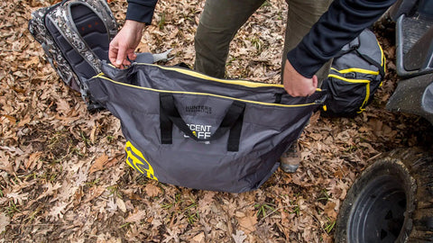 Person placing items into Scent Safe Deluxe Travel Scent Bag For Hunting Gear And Clothing Keeps Your Scent Hidden And Your Gear Scent Free