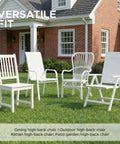 Four white high-back outdoor chairs on grass in front of brick house