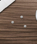 Snag This Pack Of Ten Heavy Duty Black Self Tapping Computer Screws Sized At M3 By 8.7mm on a wooden desk next to a laptop and mouse.