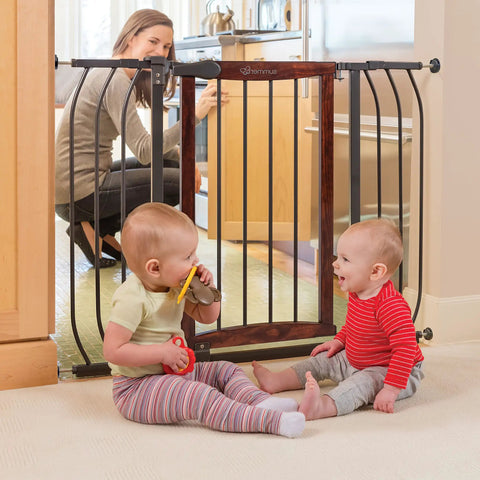 Walk Through Baby And Pet Gate With Walnut Wood And Charcoal Metal Accents in use, installed in doorway, protecting children