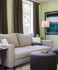 Living room with a Riverside Copper Bronze Swing Arm Floor Lamp With Cozy Warm Glow Oatmeal Drum Shade near a sofa.