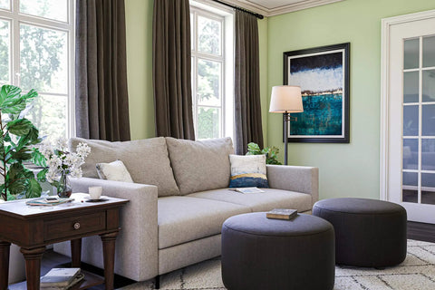 Living room with a Riverside Copper Bronze Swing Arm Floor Lamp With Cozy Warm Glow Oatmeal Drum Shade near a sofa.