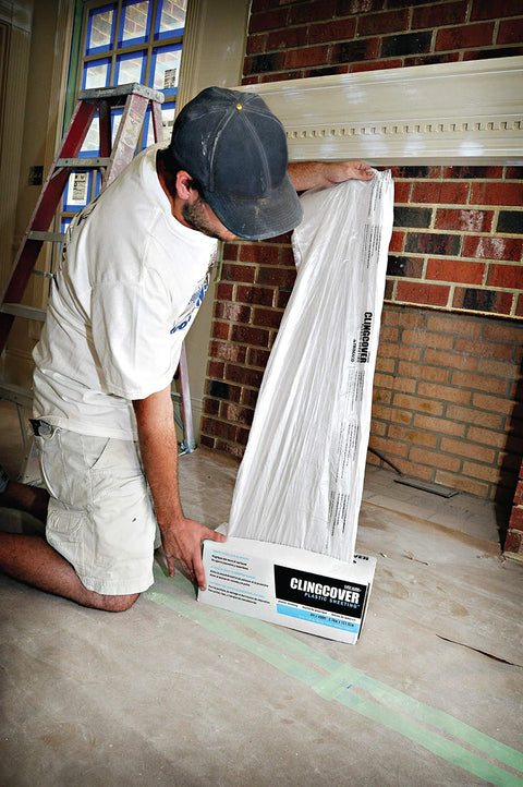 Person dispensing Cling Cover Plastic Sheeting 9 Ft By 400 Ft Dispenser Box That Grips Surfaces Without Tape for remodeling