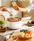 Electric Hot Pot With Steamer 2L Nonstick Saute Pan 5 In 1 Fast Easy Multifunctional Cooker on table with food