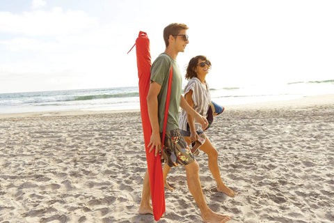 Couple on beach carrying Oversized 9 Foot UPF 50 Plus Umbrella Shelter With Privacy Panels For Sun And Rain Protection