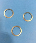 Three metal gaskets from One And A Half Inch Gasket Kit For FT 15 Series Float And Thermostatic Steam Trap 3 Pack Complete Gasket Sets Replacement Seals For Industrial Steam System Part Number 58127 on a blue surface.