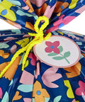 Giant 56 Inch Plastic Gift Bag With Pink And Yellow Floral Print for Large Gifts, shown with yellow tie and floral tag.