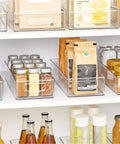 Sleek Extra Long Clear Storage Bins Pack Of 4 Heavy Duty Stackable Plastic Organizers For Deep Pantry Shelves cabinets holding spices, drinks, and snacks.