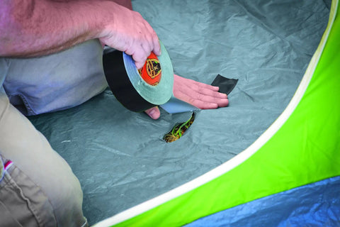 Man using Heavy Duty Black Duct Tape Double Thick Adhesive For Indoor Outdoor Use Grips Rough Surfaces Like Wood Brick