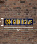 Notre Dame Fighting Irish 16 Inch Plastic Street Sign Wall Decor on brick wall, 4x16 inches, showcasing vivid team logo.