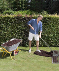 Man using Stainless Steel Lawn Level Tool With Handle For Leveling Soil And Lawn In Garden Backyard And Golf Courses Durable 7Ft Ground Leveler 30x10In For No Sweat Fast Even Turf next to wheelbarrow on grass