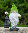 Angry Dude Gnome With Solar Lights, Large Funny Garden Statue For Outdoors, holding lantern against lush greenery