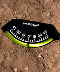 201-F Lev-O-Gage Inclinometer High Visibility Level Gauge with bright display, laying on dirt. Tilt range -45° to 45° USA Made