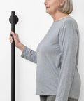 Woman gripping 24 Inch Straight Shower Grab Bar Matte Black Stainless Steel With Concealed Flanges for safety support.
