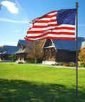 Beefy Heavy Duty Ground Flag Pole Kit 8.5 Feet Tangle Free Inground Flagpole With Windproof Prong in front of houses