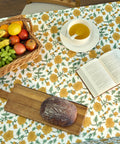 Top Tier Floral Block Print Cotton Tablecloth Yellow Rectangular Dining Cover Washable Farmhouse Kitchen Linen with fruit and bread display.