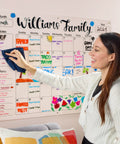 Woman using Dry Erase Whiteboard Cleaner Spray 22oz Eliminates Ghosting And Streaks Easy Wipe on family calendar board