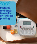 Legit Desktop Label Printer For Dorm Room And Shop Setups Game Changer Organization Hack With Vibrant Color Tape Rolls Slim Portable Frame For Quality Prints Every Time on a table with nail polish and keys.