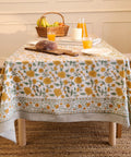 Top Tier Floral Block Print Cotton Tablecloth Yellow Rectangular Dining Cover Washable Farmhouse Kitchen Linen on a dining table.