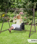 7 Foot Rattan Porch Swing Frame Heavy Duty Outdoor Stand With Metal Frame 4 Hanging Rings Sturdy Built To Last For Stability A Frame Design For Backyard Patio Or Garden Up To 1200 Lbs in a garden setting with a person swinging.