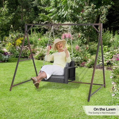 7 Foot Rattan Porch Swing Frame Heavy Duty Outdoor Stand With Metal Frame 4 Hanging Rings Sturdy Built To Last For Stability A Frame Design For Backyard Patio Or Garden Up To 1200 Lbs in a garden setting with a person swinging.