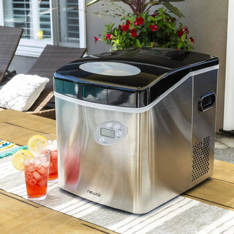 Portable Countertop Ice Maker Delivers 12 Bullet Ice Cubes in 7 Minutes; stainless steel unit on outdoor table, next to drinks.