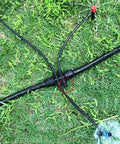 Close-up of Bulk 45 Pack Quick Connect Drip Irrigation Fittings Kit with tubing and tee connector on grass.
