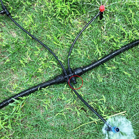 Close-up of Bulk 45 Pack Quick Connect Drip Irrigation Fittings Kit with tubing and tee connector on grass.