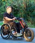 A8 Electric Handcycle Wheelchair Power Attachment Upgrade Kit in red, 48V 1000W, affixed to manual wheelchair on park path