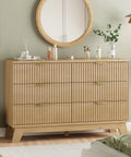 Fluted Dresser for Bedroom With Six Drawers and Totally Modern Oak Finish 48 Inch Wide Wooden Dresser TV Stand With Metal Handle Space Saving Closet Organizer for Living Room Hallway Natural Oak in a bedroom setting with decor on top.