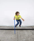 Person balancing on Slackhouse 3.0 Indoor Slackline Structure Built For Gym And Home Training with a blue pole.