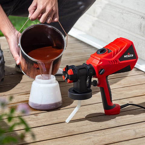 Pouring paint into a handheld HVLP spray gun with adjustable airflow and 600W power for home projects three spray patterns and four nozzles