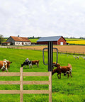 Beefy 24 Inch Fence Post Driver With Dual Handles, black steel construction, shown on wooden fence in farm landscape