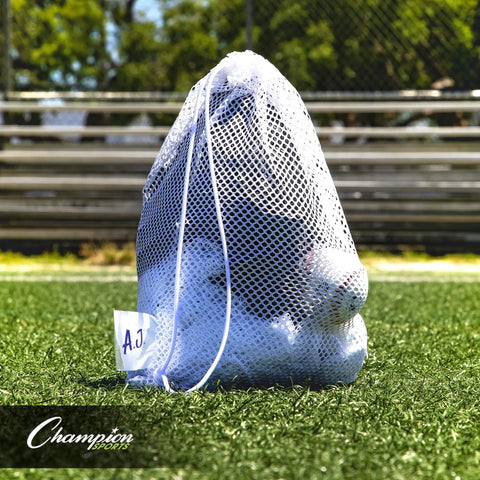 Breathable Mesh Sports Equipment Bag 12x18 Inch on grass, filled with sports gear, heavy duty nylon drawstring, ID tag visible.