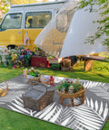 Waterproof Outdoor Rug 5x8 Feet Double-Sided Palm Leaf Pattern Grey And White Plastic Patio Mat at a vibrant garden setting