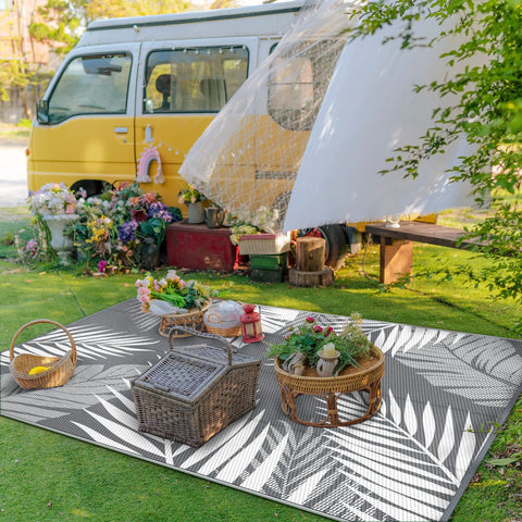 Waterproof Outdoor Rug 5x8 Feet Double-Sided Palm Leaf Pattern Grey And White Plastic Patio Mat at a vibrant garden setting
