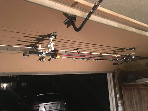 Easy Clip Garage Door Storage Rack With Hooks For Fishing Rods Kayak Paddles And Light Garden Tools Installs In Seconds No Tools Needed Clips To Garage Door Hinge Tubes For Quick No Fuss Organization showing fishing rods stored on a garage door rack