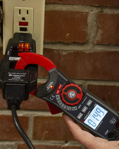 Must Have AC Line Splitter And GFCI Outlet Tester With Five Visual Indicators measuring outlet voltage on brick wall