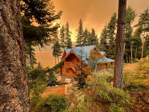 Scenic view of a cabin surrounded by trees during a sunset. Ideal setting for Wildfire Protection Sprinkler System With Bracket And Hardware.