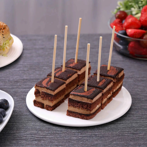 Cake bites with Bamboo Skewers 6 Inch 200 Pack For Appetizers, Fruit Kabobs on a white plate, strawberries in background