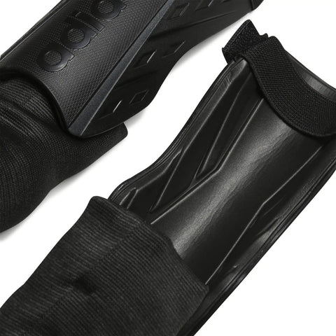 Close-up of black Soft Ground Soccer Shin Guards With Pro Grade EVA Shield, featuring durable black shielding and strap details.