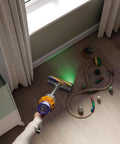 V12 Detect Slim Absolute Cordless Vacuum Cleaner with High Suction Power cleaning wooden floor with toys scattered around