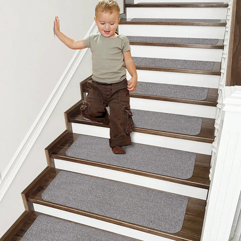 Child on stairs with Non Slip Stair Treads 15 Pack Carpet Mats For Indoor Stair Runners 28 By 9 Inches Grey 100 Percent Polyester With TPE Backing Protect Floors And Keep Kids And Pets Safe.