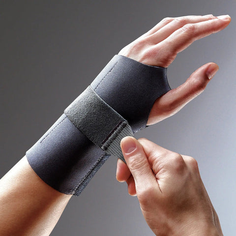 Left Hand Compression Wrist Brace With Three Adjustable Straps For A Custom Fit And Moderate Support Lets Your Fingers Move Naturally Easy To Use Black Size L/XL worn on a hand and being adjusted.
